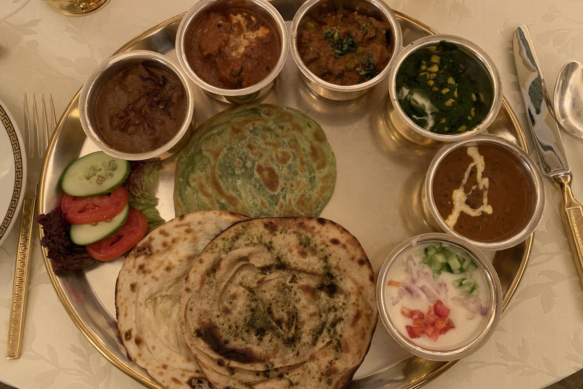 An elaborate Rajasthani thali platter with an array of curries, dal, roti and accompaniments served on a silver plate
