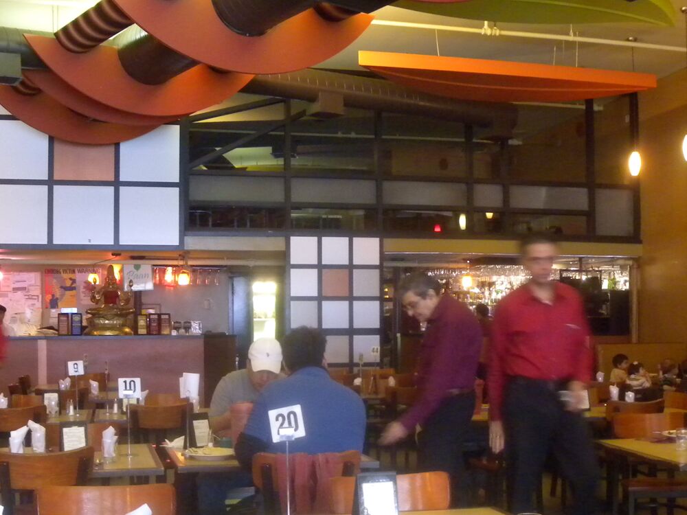 A warm restaurant dining room with wooden tables representative of the Toronto Parkdale location
