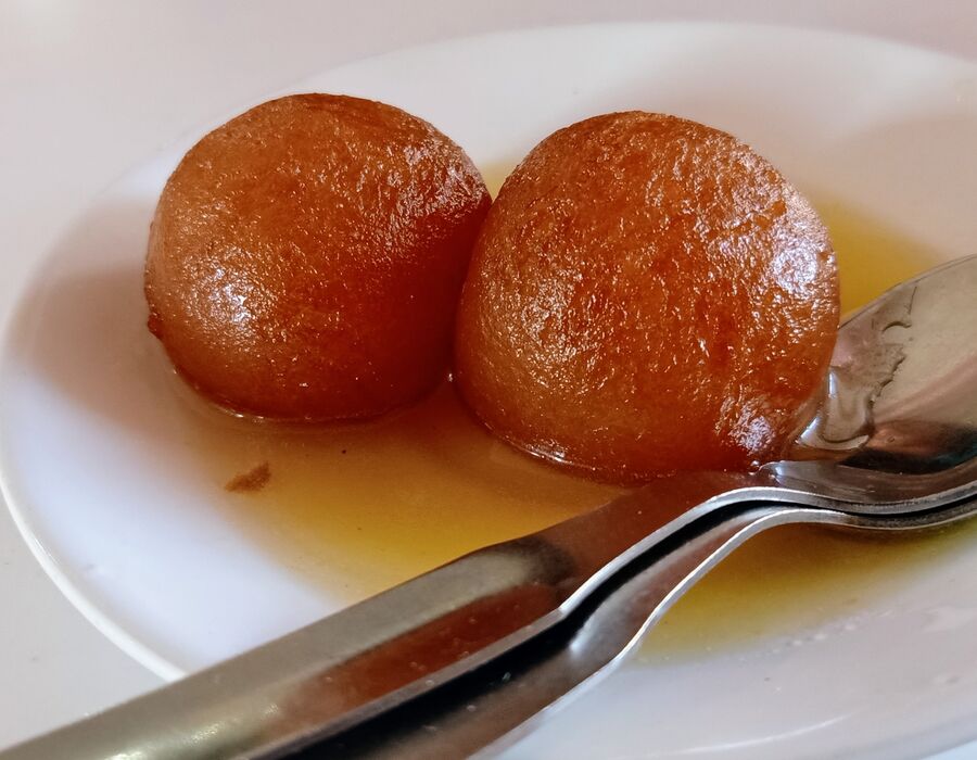 Gulab Jamun, soft milk-solid dumplings soaked in rose-scented syrup